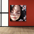 Framed artwork of a woman's face with cherry blossoms on a red wall.
