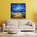 Painting of a person standing in a field under a starry sky above a beige sofa in a living room.